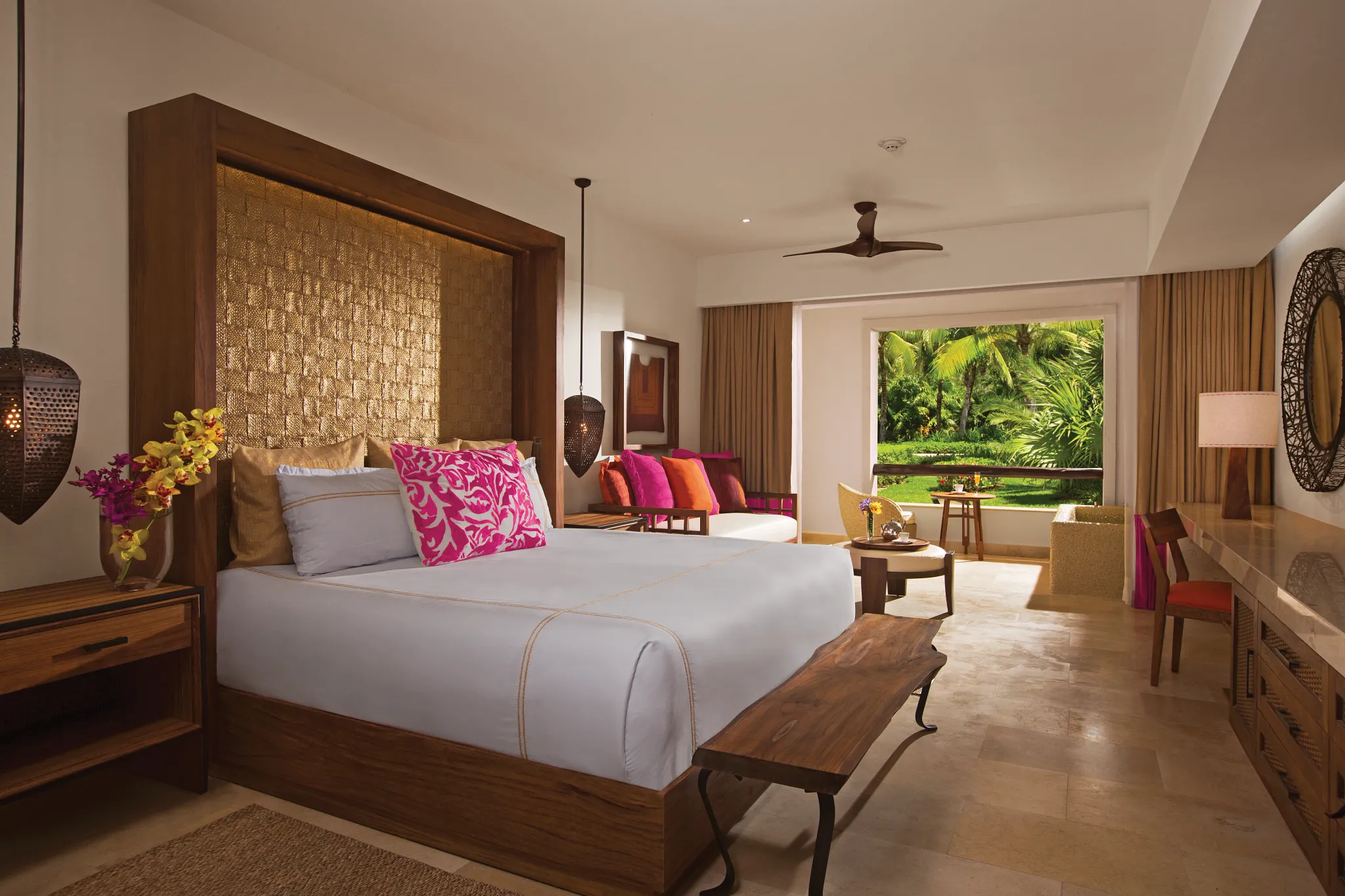 Junior Suite with king bed and resort view balcony at Secrets Akumal Riviera Maya surrounded by tropical greenery.